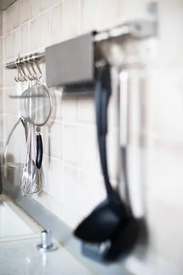 a whisk and utensils are hanging on a kitchen wall at Konaci Brvenik Suites in Kopaonik