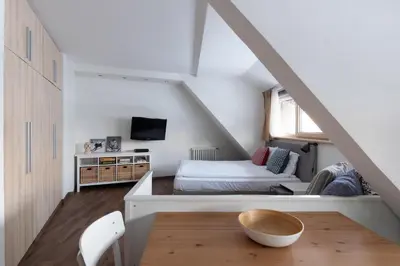 a attic room with a bed and a table at Konaci Brvenik Suites in Kopaonik
