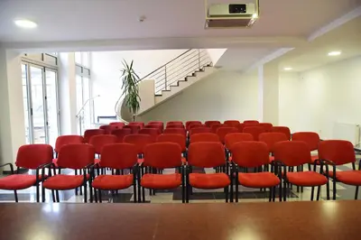 a conference room with red chairs and a staircase at Apartments Mavesa in Vrnjačka Banja