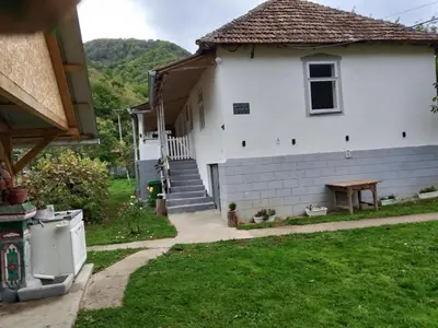 a white house with a table in the yard at Seosko turisticko domacinstvo Milanovic in Žuč