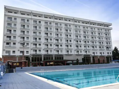 a hotel with a swimming pool in front of a building at Apartman Vića in Jagodina