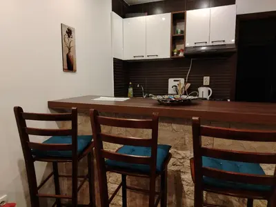 a kitchen with a bar with four chairs around it at Drašković lux Goč in Goč