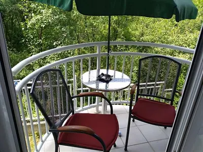 a balcony with two chairs and a table and an umbrella at Smeštaj Galerija in Soko Banja