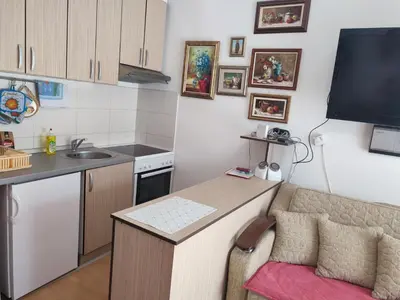 a small kitchen with a table and a couch at Smeštaj Galerija in Soko Banja