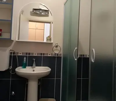 a bathroom with a sink and a mirror and a shower at Smeštaj Galerija in Soko Banja
