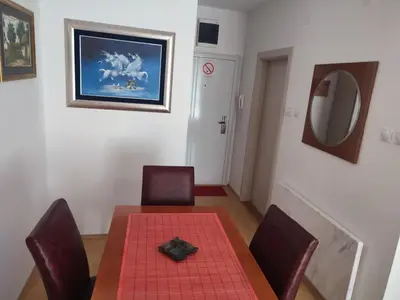 a dining room with a table and chairs and a mirror at Smeštaj Galerija in Soko Banja