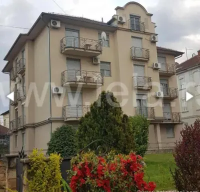 a building with balconies and flowers in front of it at Apartman Fazan in Vrnjačka Banja