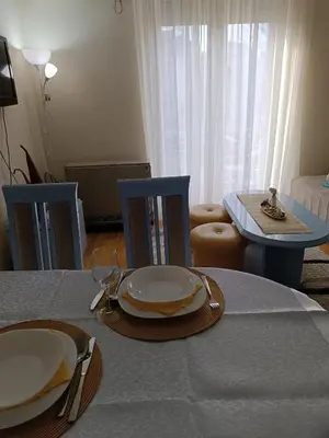 a dining room table with plates on top of it at Apartman Fazan in Vrnjačka Banja