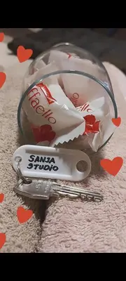 a glass container with a pair of scissors and a pair of hearts at Studio Sanja in Niš