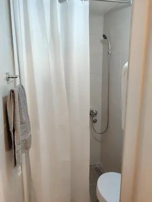 a bathroom with a shower curtain and a toilet at Studio Sanja in Niš