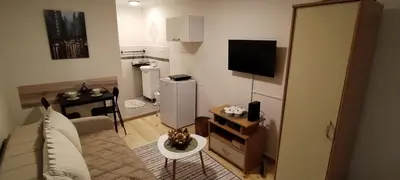 a small living room with a television and a kitchen at Studio Sanja in Niš