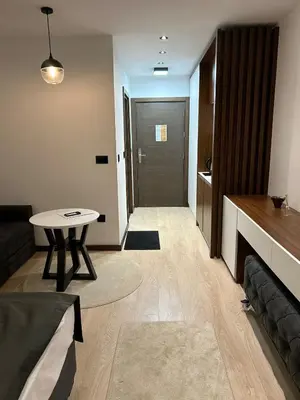 a living room with a couch and a table and a door at Apartman Minja - Hotel Zoned Kopaonik in Kopaonik