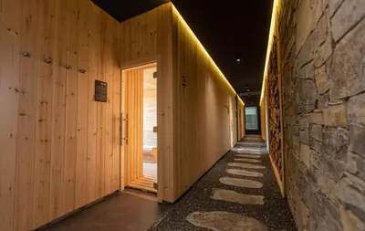 a hallway with wooden walls and a stone wall at Apartman Minja - Hotel Zoned Kopaonik in Kopaonik