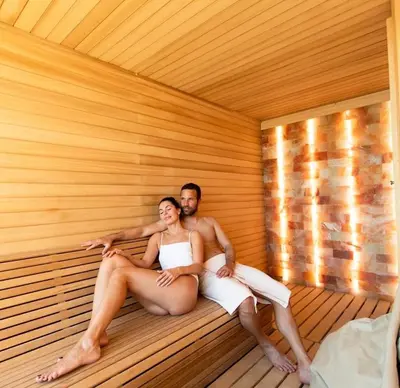 a man and woman sitting in a sauna at Apartman Minja - Hotel Zoned Kopaonik in Kopaonik