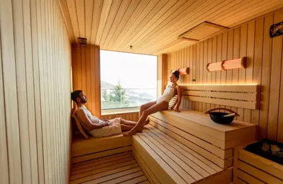 a man and woman sitting in a sauna at Apartman Minja - Hotel Zoned Kopaonik in Kopaonik