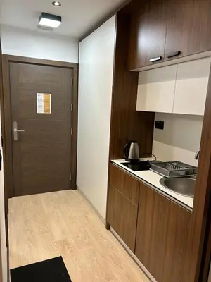 a small kitchen with a door and a sink at Apartman Minja - Hotel Zoned Kopaonik in Kopaonik