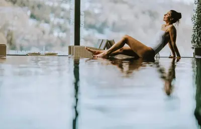 a woman sitting on the floor in a flooded room at Apartman Minja - Hotel Zoned Kopaonik in Kopaonik