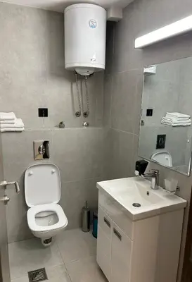 a bathroom with a toilet and a sink and a mirror at Apartman Minja - Hotel Zoned Kopaonik in Kopaonik