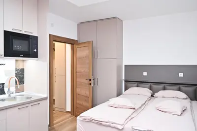 a small bedroom with a bed and a sink at Studio Idila in Raška
