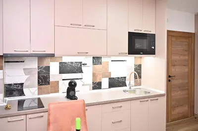 a kitchen with white cabinets and a sink at Studio Idila in Raška
