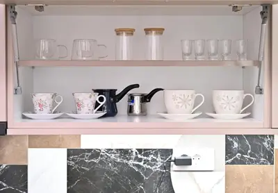 a shelf with cups and saucers on it at Studio Idila in Raška