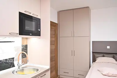 a bathroom with a sink and a tv on a cabinet at Studio Idila in Raška