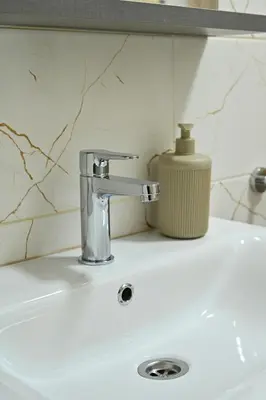 a bathroom sink with a faucet and a soap dispenser at Studio Idila in Raška
