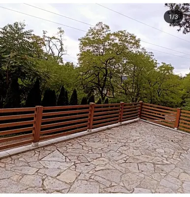a wooden fence in front of a stone patio at Studio Idila in Raška