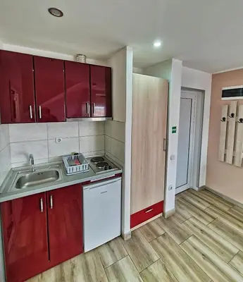 a kitchen with red cabinets and a sink at Vila Aleksandra 2 Studio 14 in Soko Banja