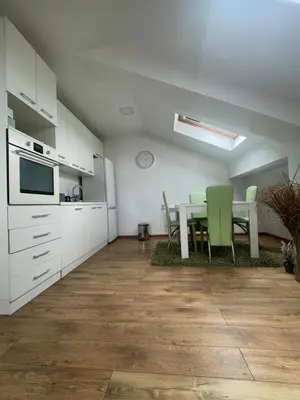 a kitchen and dining room with a table and chairs at Apartman Sinđelić lux in Pirot