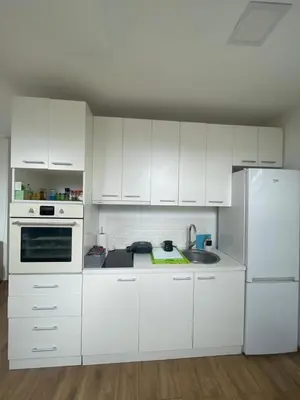 a kitchen with white cabinets and a white refrigerator at Apartman Sinđelić lux in Pirot