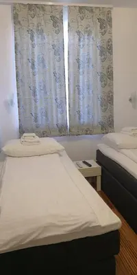 a bedroom with two beds and a window with curtains at Kraljevi Cardaci SPA Aartment 1027 für 6 Personen in Kopaonik