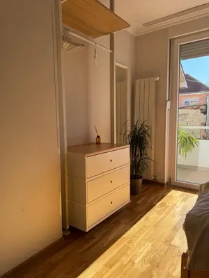 a bedroom with a dresser and a large window at Studio 4 in Pirot