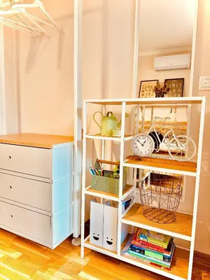 a white book shelf in a room with a bike at Studio 4 in Pirot