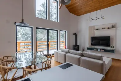 a living room with a couch and a table and chairs at Gorska Vila in Kopaonik