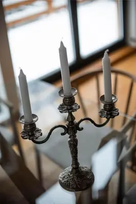 a candle holder with three candles on a table at Gorska Vila in Kopaonik