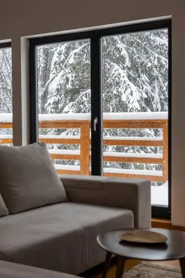 a living room with a couch in front of a window at Gorska Vila in Kopaonik