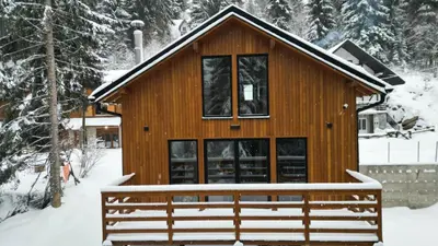 a log cabin in the snow with a large window at Gorska Vila in Kopaonik