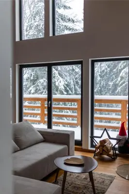 a living room with a couch and four windows at Gorska Vila in Kopaonik