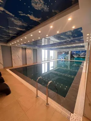 a large swimming pool in a building with a ceiling at A 14 President Kopaonik in Raška