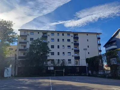 a white building with a basketball court in front of it at Forest River Sokobanja in Soko Banja