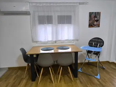 a dining room table with chairs and a window at Forest River Sokobanja in Soko Banja