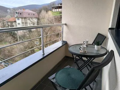 a balcony with a table and a laptop on it at Forest River Sokobanja in Soko Banja
