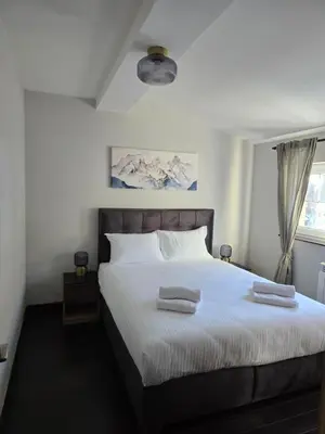 a bedroom with a large bed with two towels on it at Weg City Apartmani in Brzeće