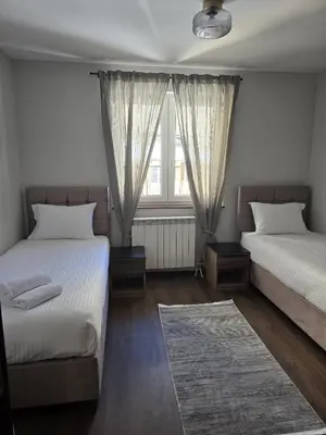 a bedroom with two beds and a window at Weg City Apartmani in Brzeće
