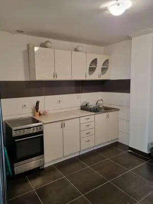 a kitchen with white cabinets and a stove at Vucko Apartmani in Prokuplje
