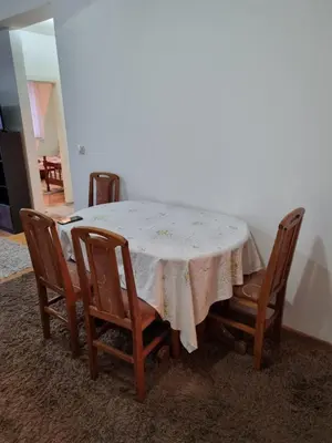 a table with four chairs and a white table cloth at Vucko Apartmani in Prokuplje