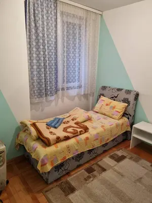 a small bedroom with a bed and a window at Vucko Apartmani in Prokuplje