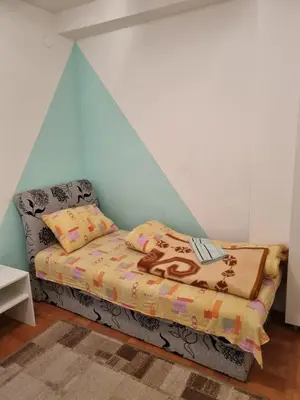 a bed in a room with a blue wall at Vucko Apartmani in Prokuplje
