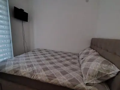 a bed sitting in a corner of a room at Apartman Peca in Vrnjci